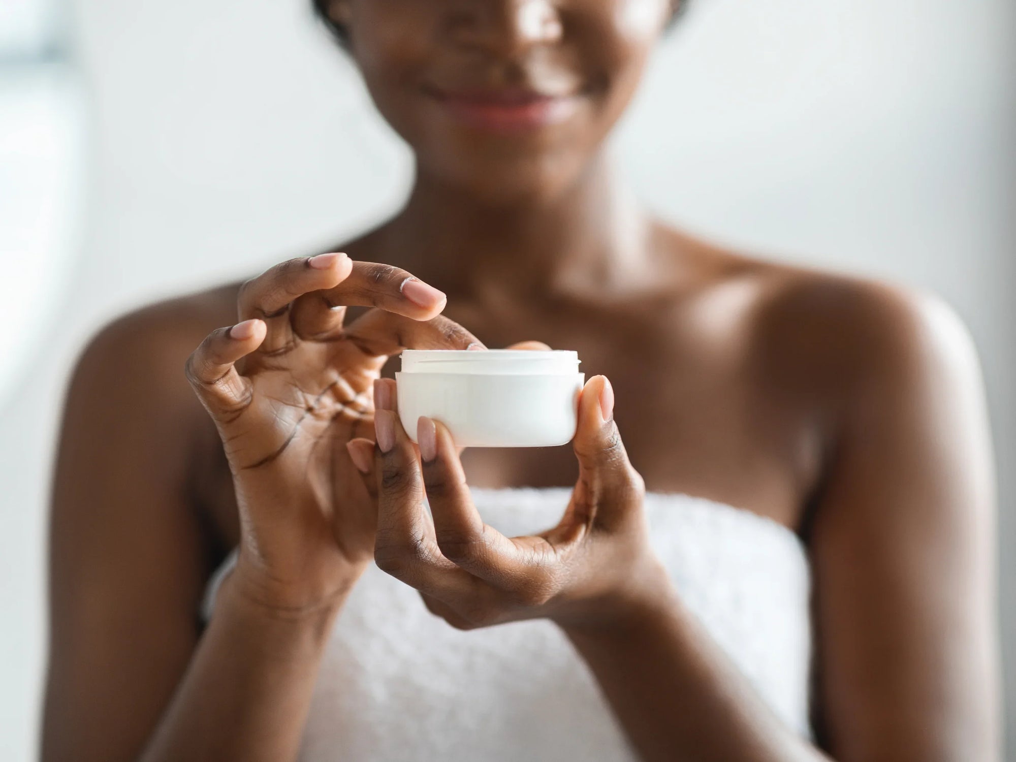 woman with jar of skin care