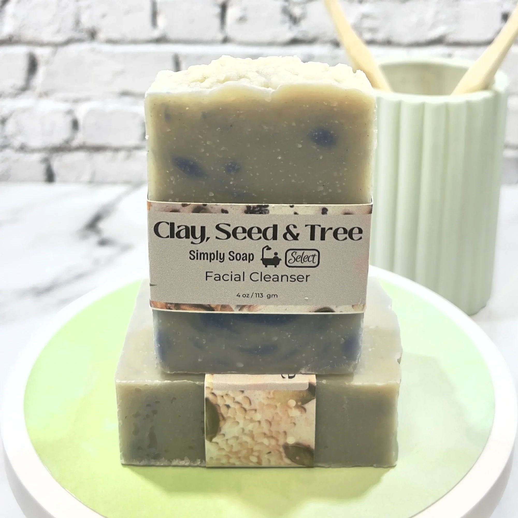 Two bars of soap with 'Clay, Seed & Tree' branding on a white plate.