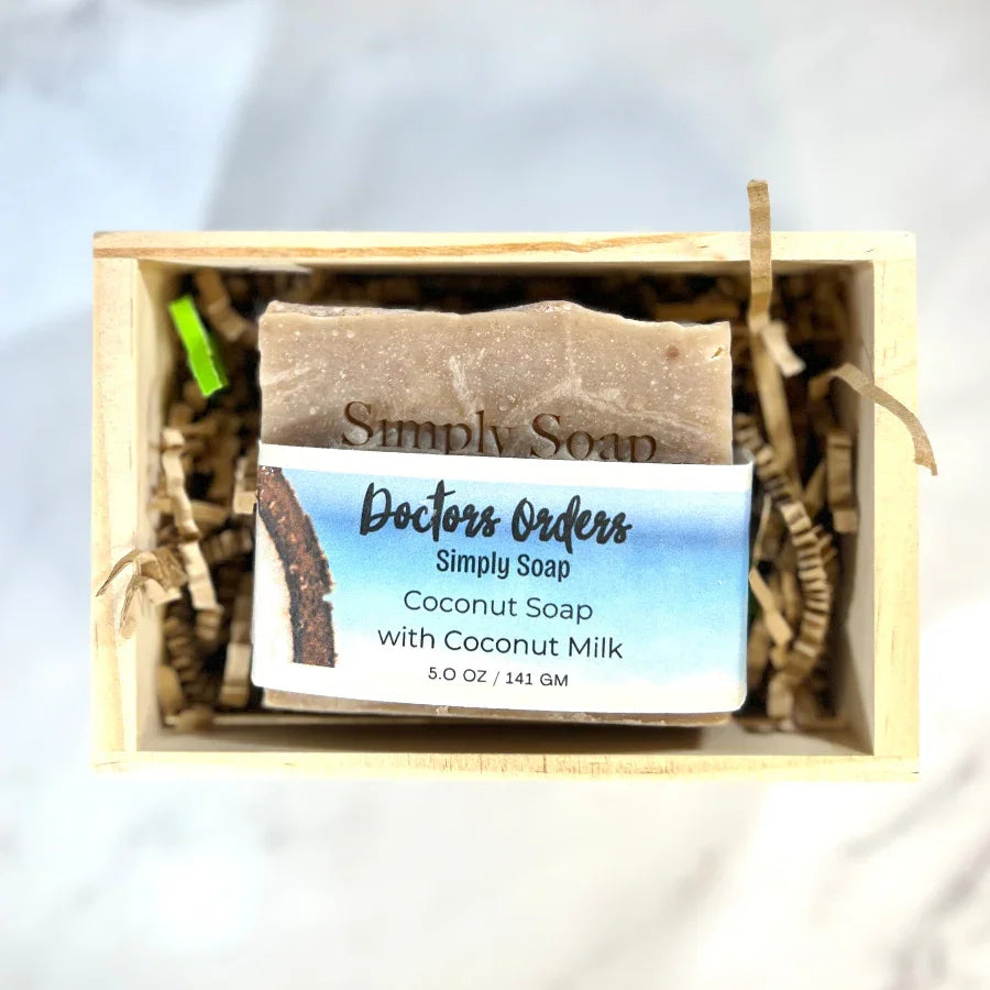 Bar of Coconut soap in a wooden box with a label on a white background