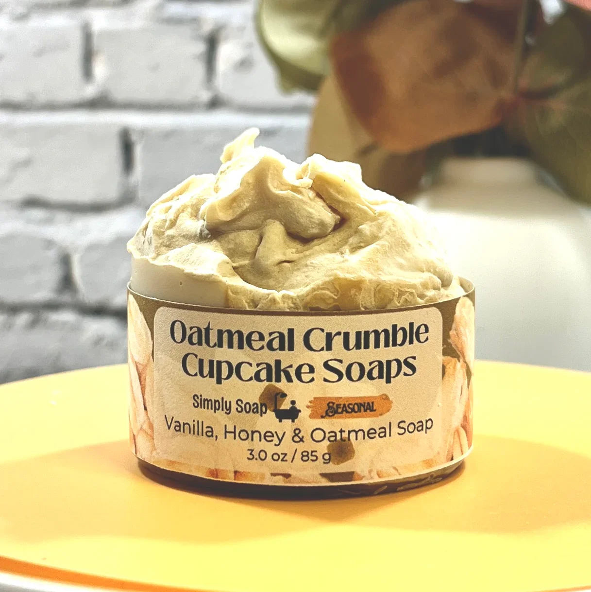 One Oatmeal Crumble Cupcake Soaps with a brick wall background