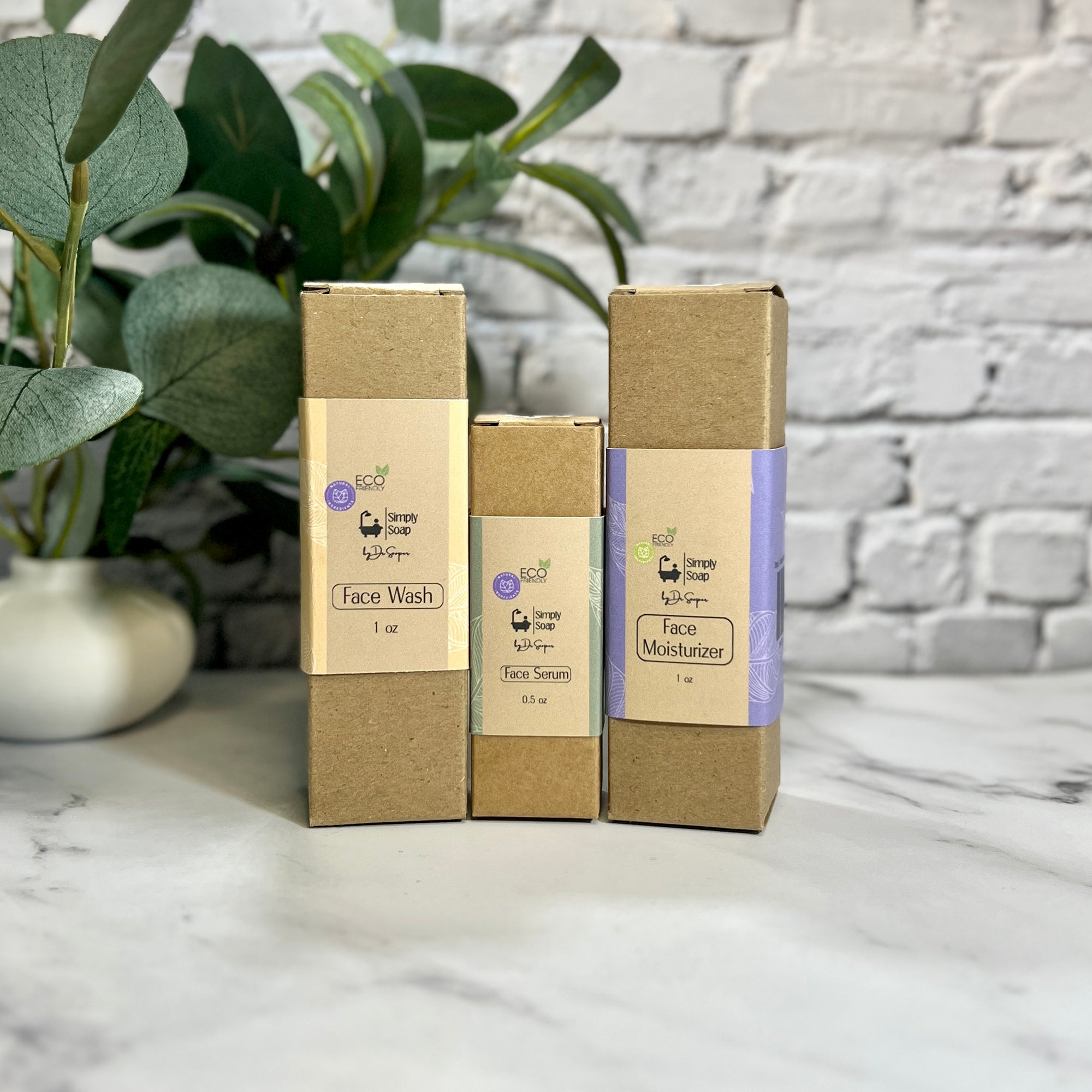 Three skincare product boxes on a marble surface with a plant and brick wall in the background.