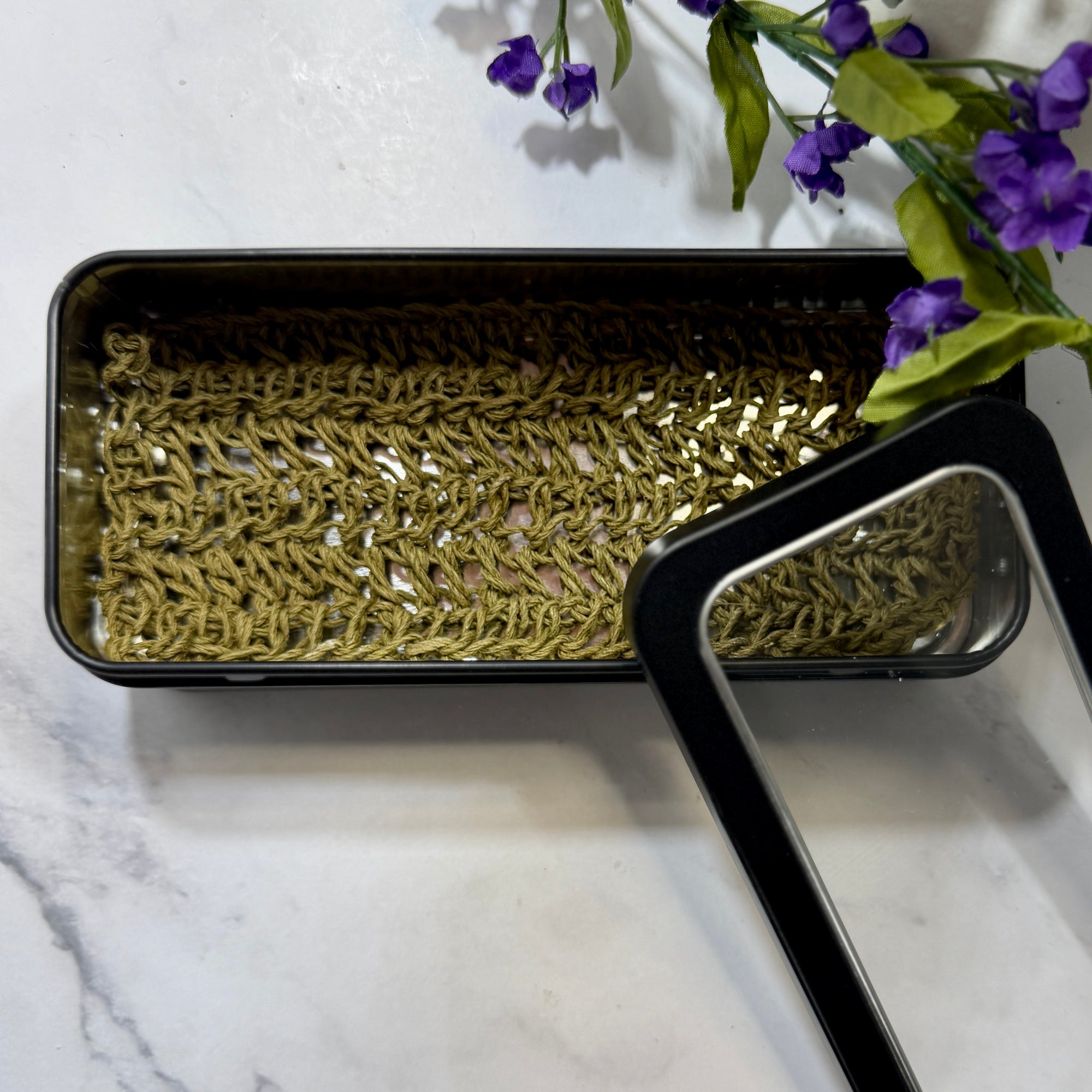 Black metal box with green hemp soap lift inside