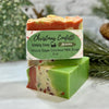 Two bars of soap with a 'Christmas Confetti' label on a marble surface with a blurred festive background.