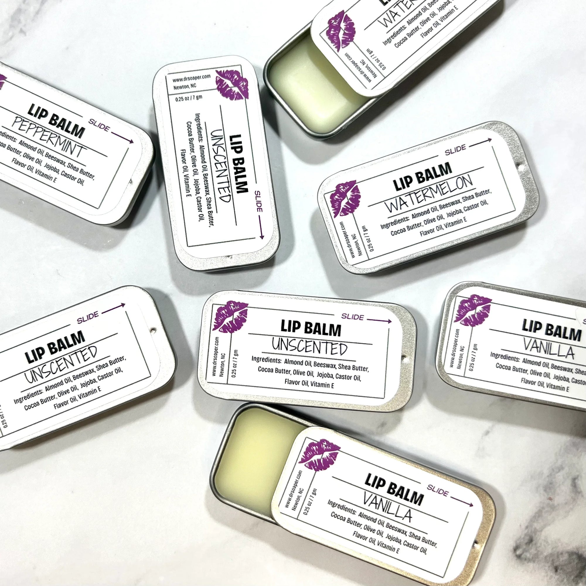 Dr. Soaper Natural Lip Balm tins, multiple with 2 tins open on marble background