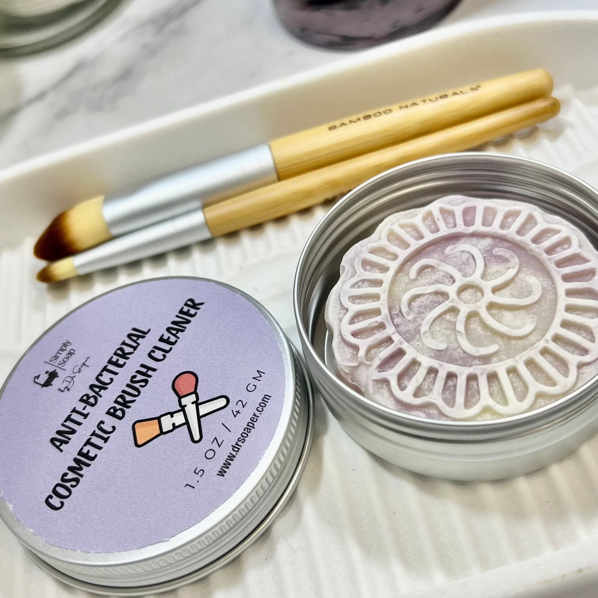 Dr Soaper's Cosmetic Brush Cleaner open with lid next to tin