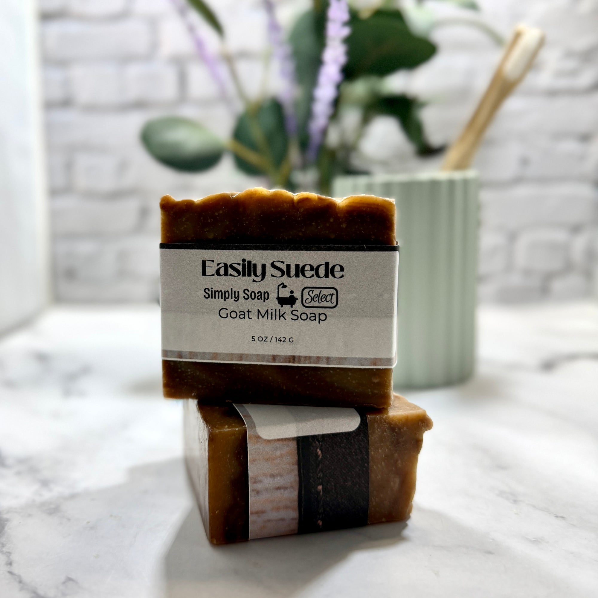 Two bars of goat milk soap with a 'Simply Soap' label on a marble surface.