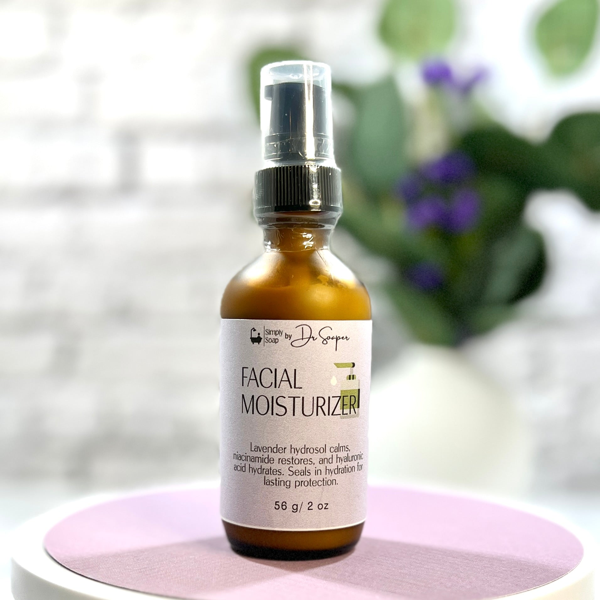 Facial moisturizer bottle on a pink stand with a blurred natural background