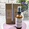 Facial moisturizer bottle and packaging on a white surface with a plant in the background