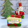 Christmas-themed soap with a snowman decoration and decorative tree on a marble surface.