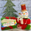 Two felted soap bars with a Christmas tree decoration in the background
