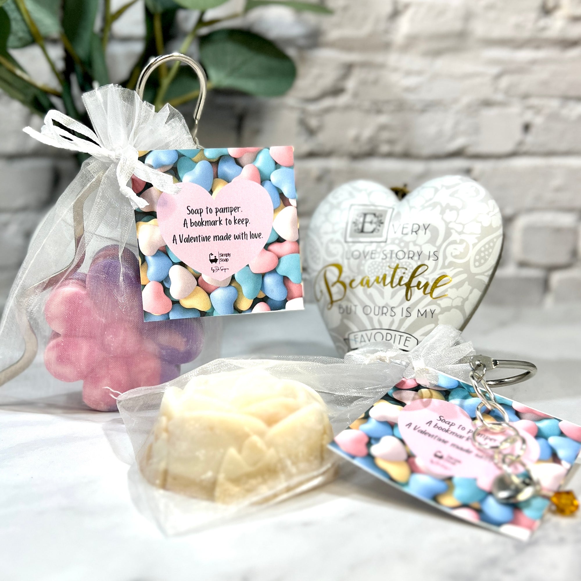 Collection of small gifts including a soap, keychain, and heart-shaped item on a textured surface.