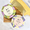 Two hair care bars with labels and a wooden comb on a marble surface