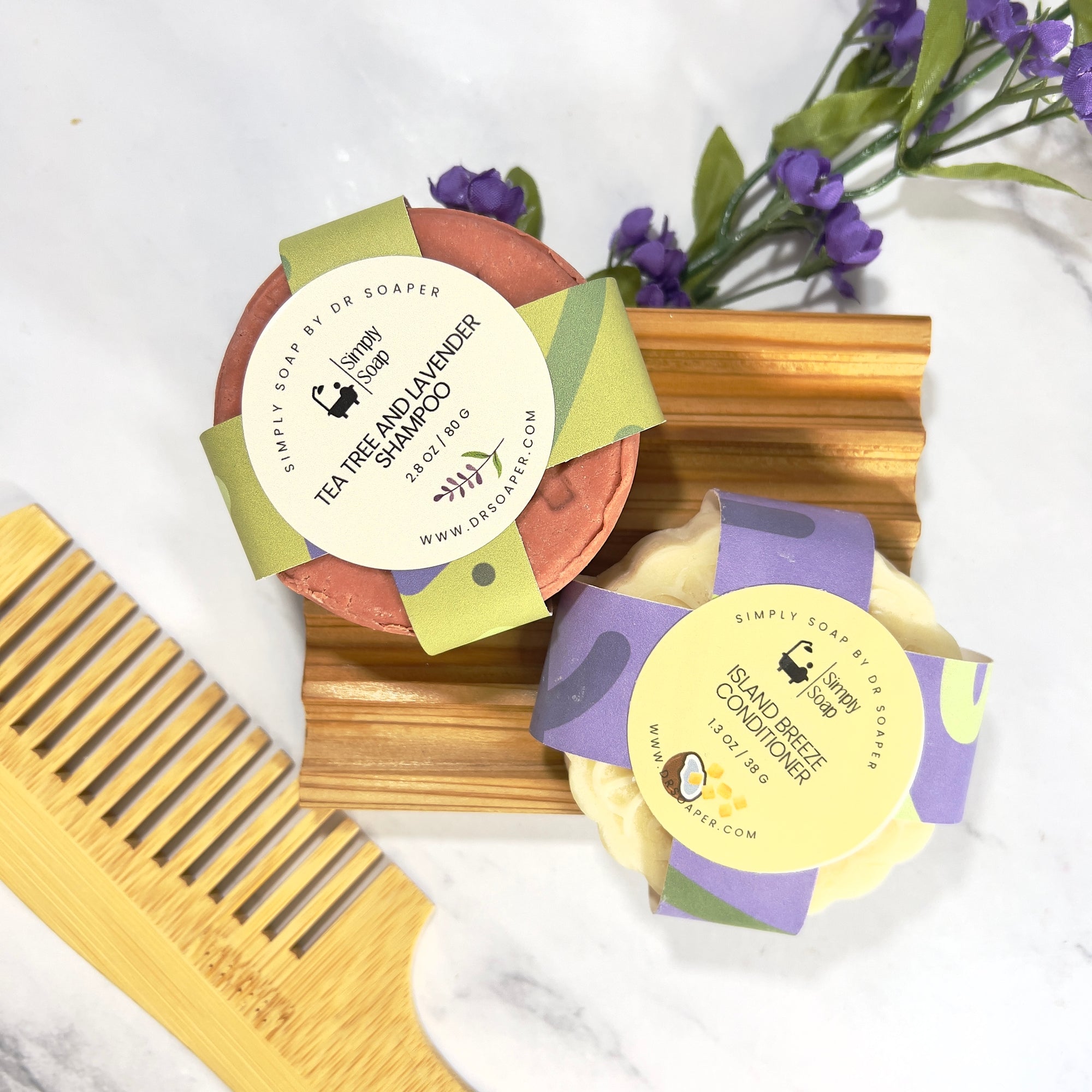 Two hair care bars with labels and a wooden comb on a white background