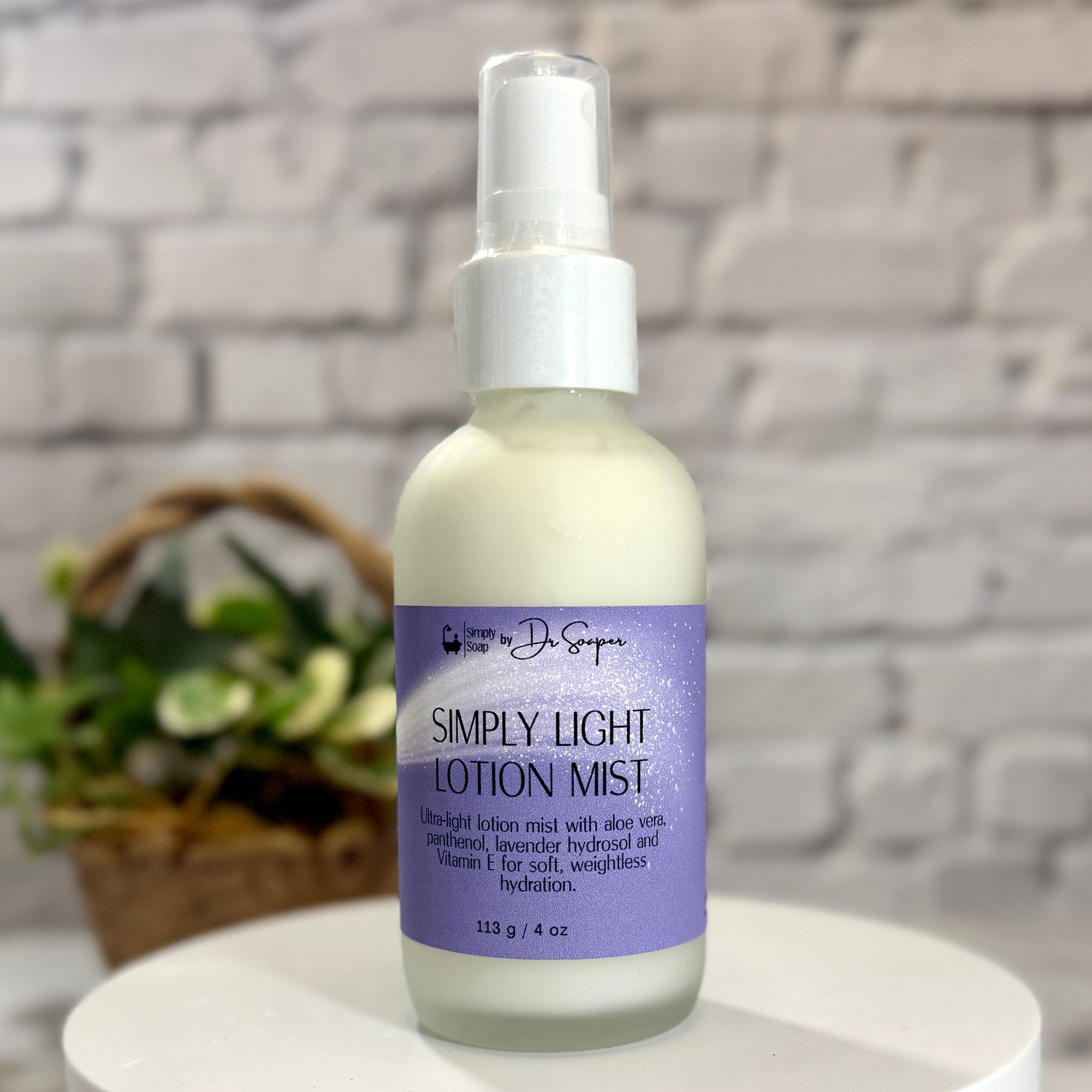 Bottle of 'Simply Light Lotion Mist' on a white surface with a gray brick wall background.