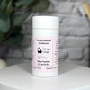 Simply Natural Deodorant can on a white surface with a blurred background