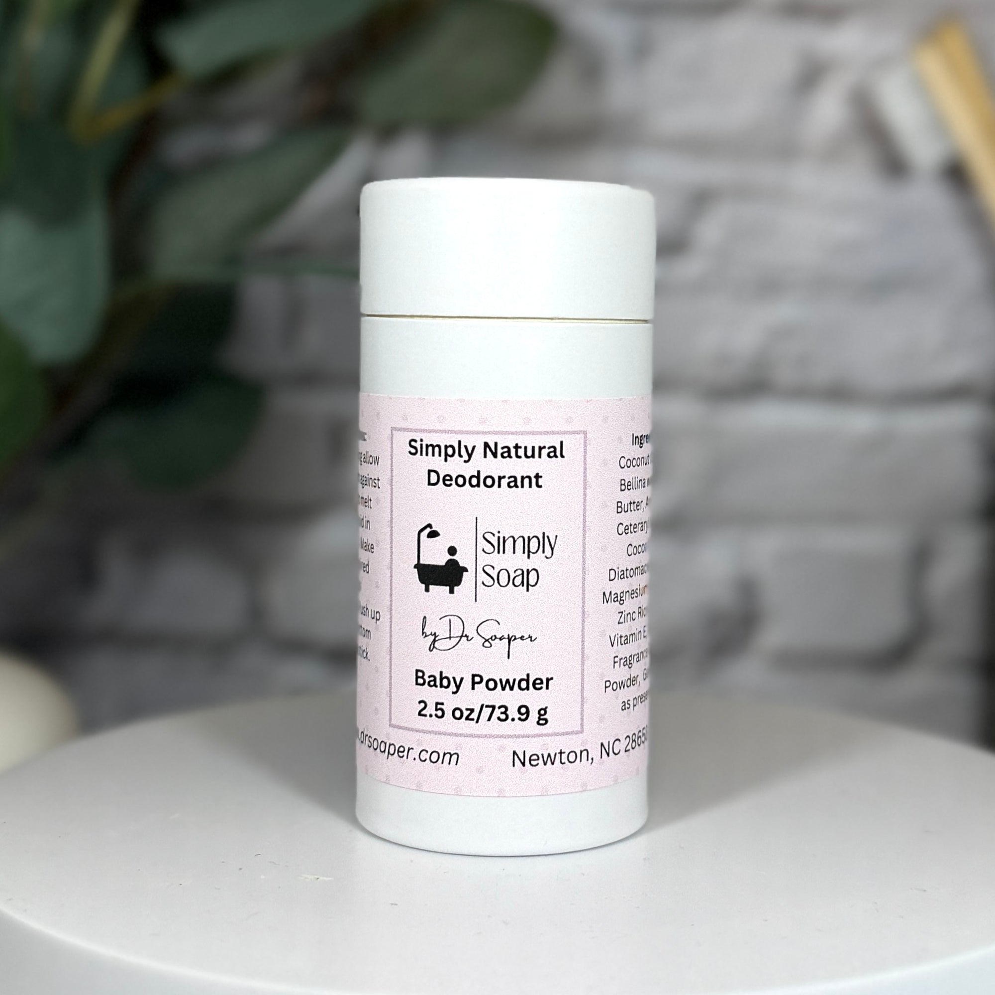 Simply Natural Deodorant can on a white surface with a blurred background