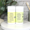 Two containers with labels on a white surface with a blurred background