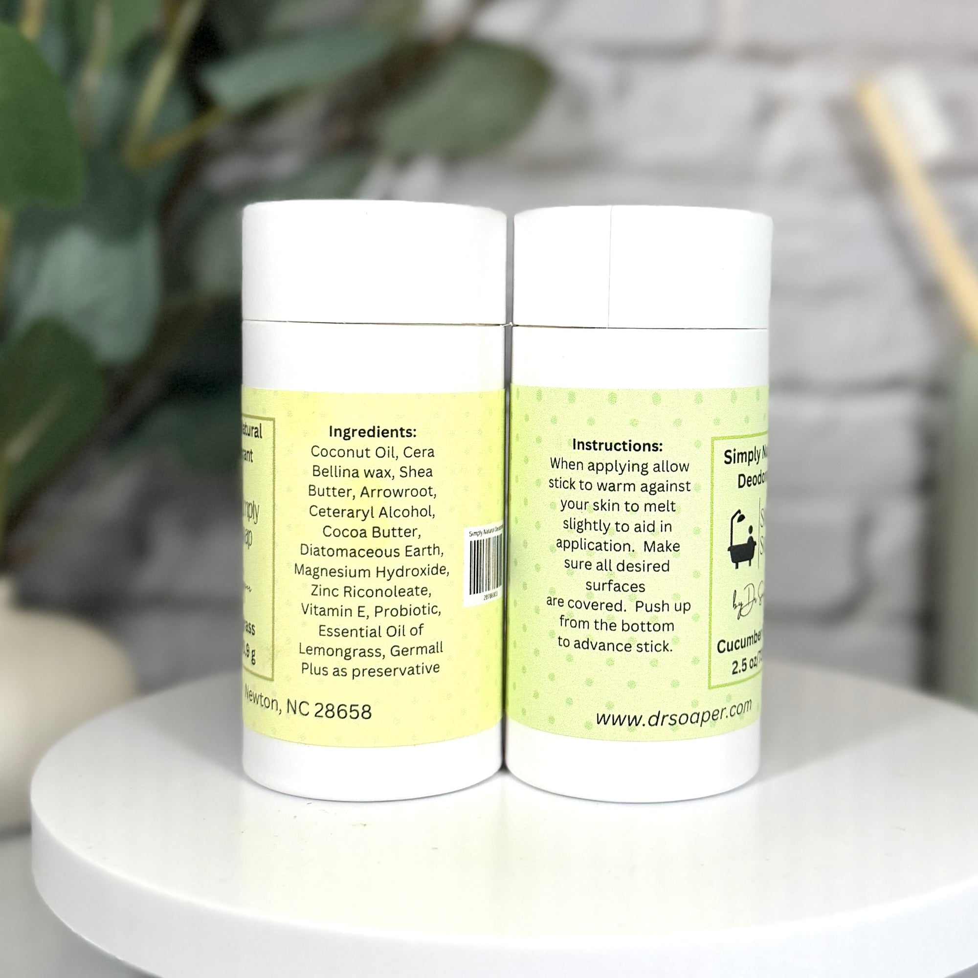 Two containers with labels on a white surface with a blurred background