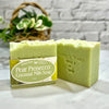 Green soap bar with packaging labeled 'Pear Prosecco Coconut Milk Soap' on a marble surface.