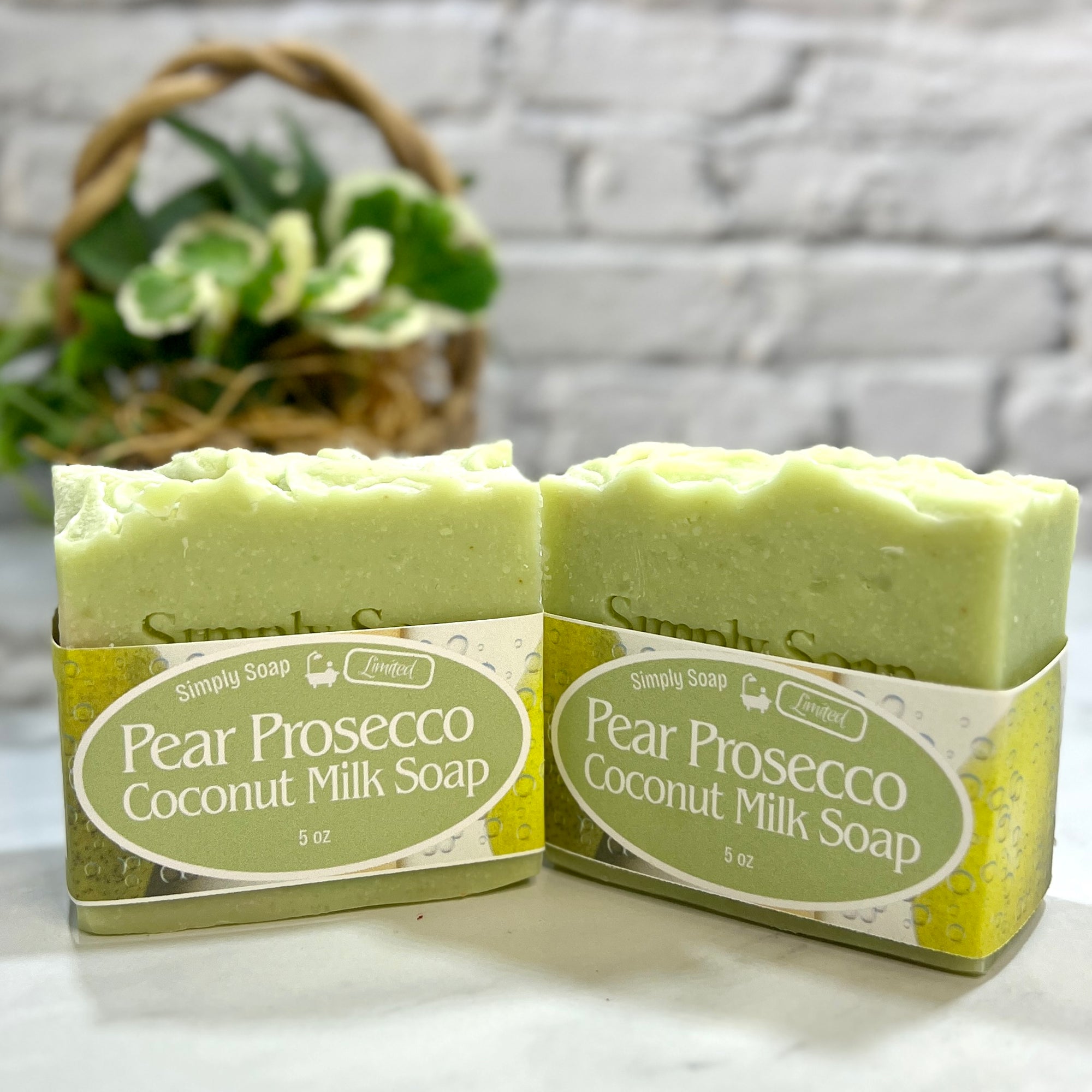 Two bars of Pear Prosecco Coconut Milk Soap with a label on a light surface.
