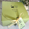 A light green gift box for Simply Soap by Dr. Soaper, tied with a pale yellow ribbon and a 'Gift for You' Realtor tag, set on a marble surface.