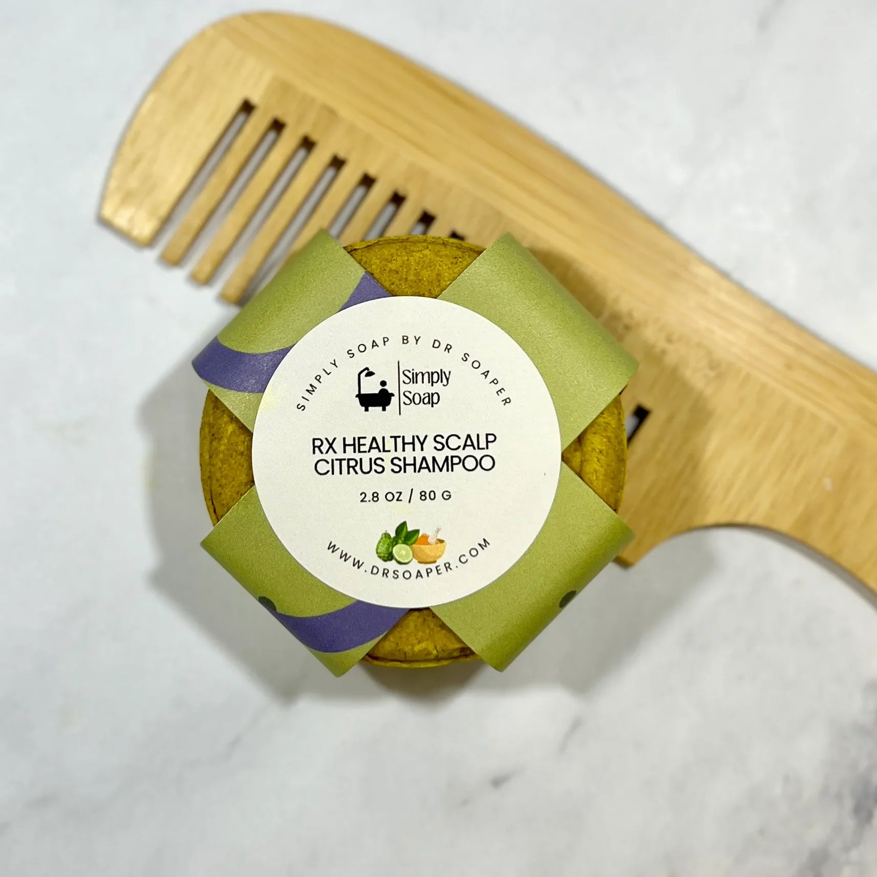 Bar of soap with a label and a wooden comb on a white background