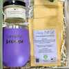 A gift set from Simply Soap in a white box with shredded paper filler, featuring a purple insulated tumbler with 'simply because, as well as hand cream and 4 bath salts. 