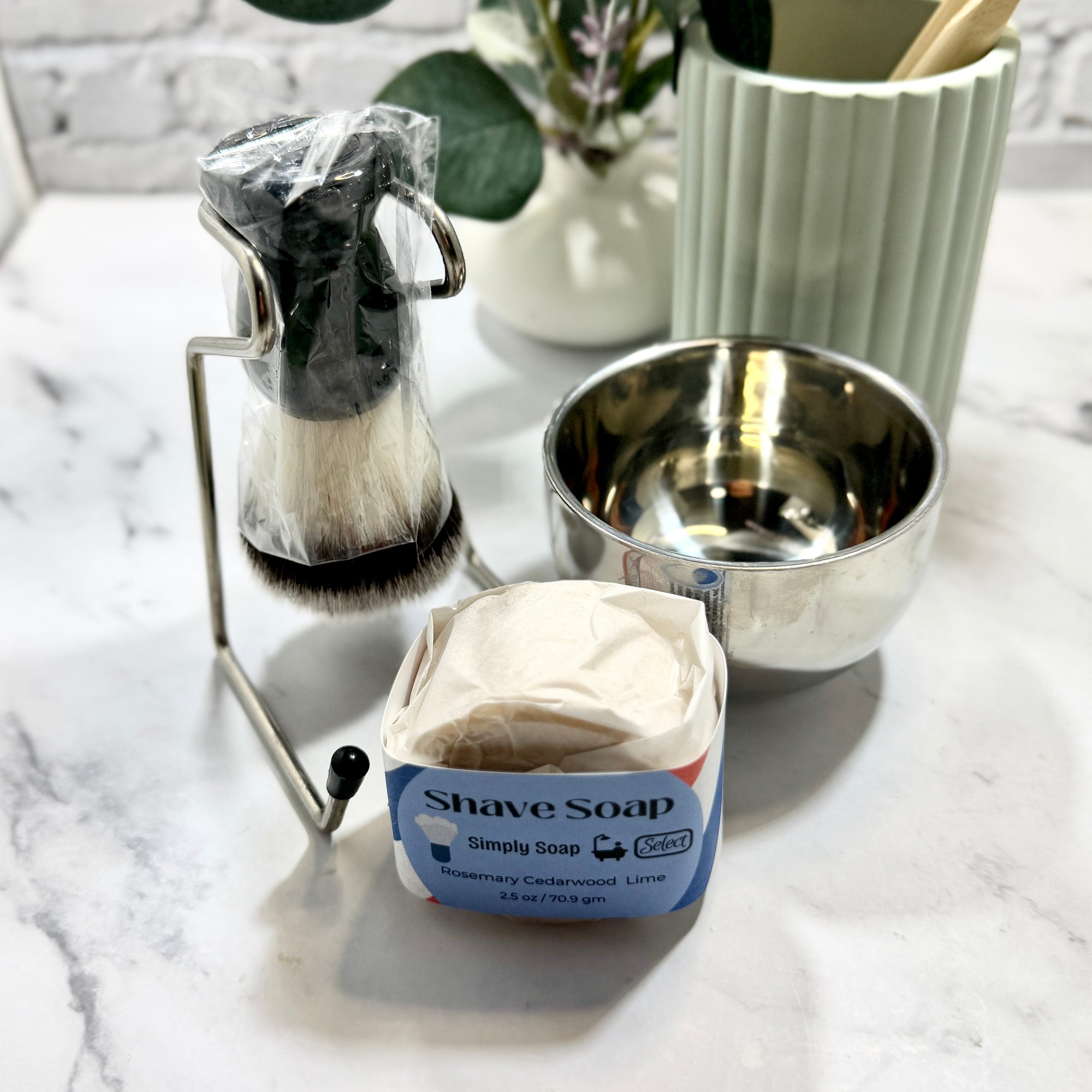 Shave soap container on a marble surface with shaving brush and bowl in the background