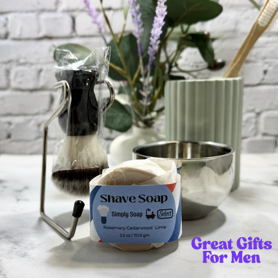 Shave soap with a brush and plant in the background on a white surface.
