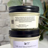 Two stacked jars of Simply Soap Silk and Shea Hand Cream, showing the back label of the top jar and the front label of the bottom jar against a soft-focus background.
