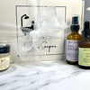 Set of skincare products including bottles and a jar on a marble surface with a branded box in the background.