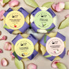 Four Solid conditioner bars with colorful labels on a light background with flowers.