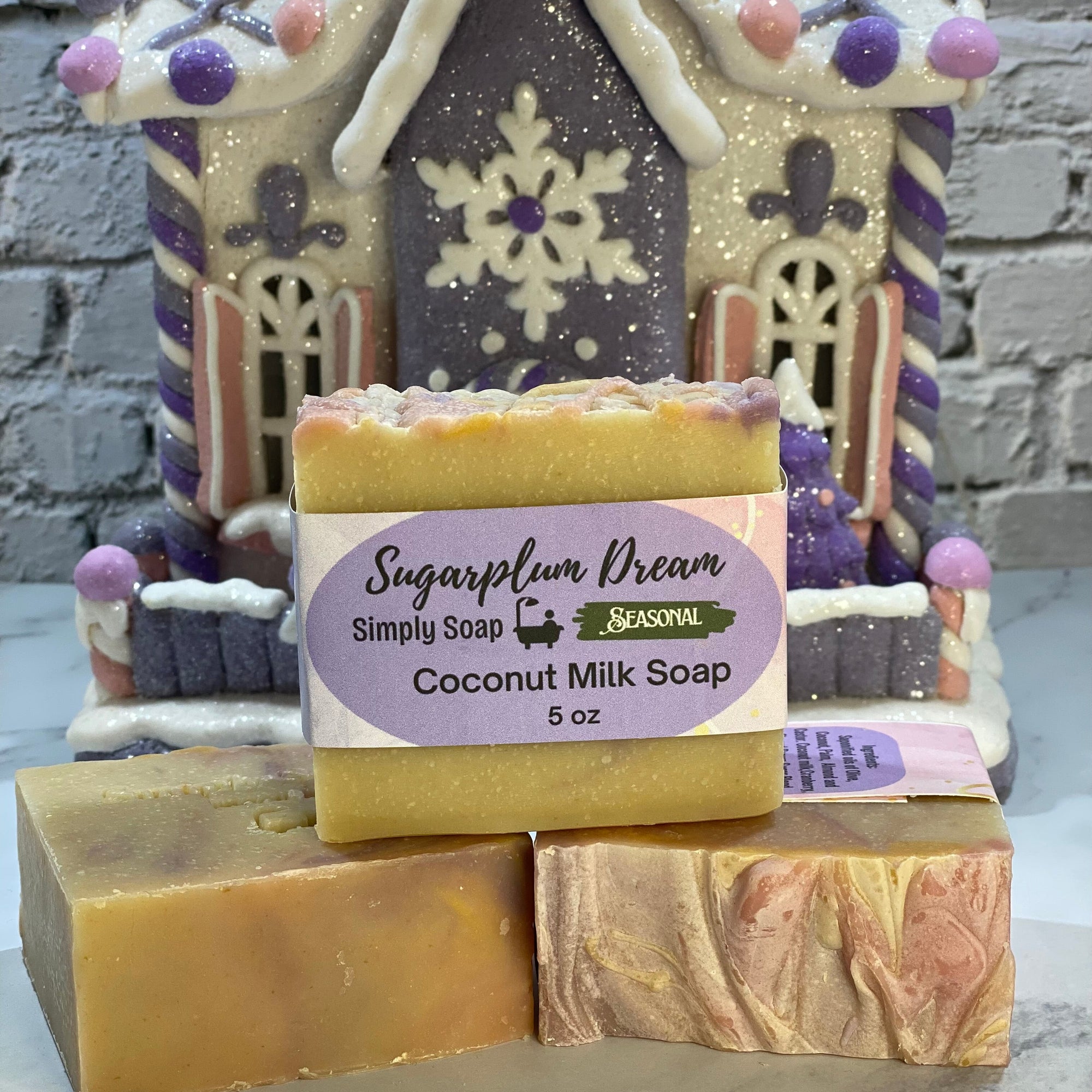 Coconut milk soap bar with 'Sugarplum Dream' label in front of a decorative house