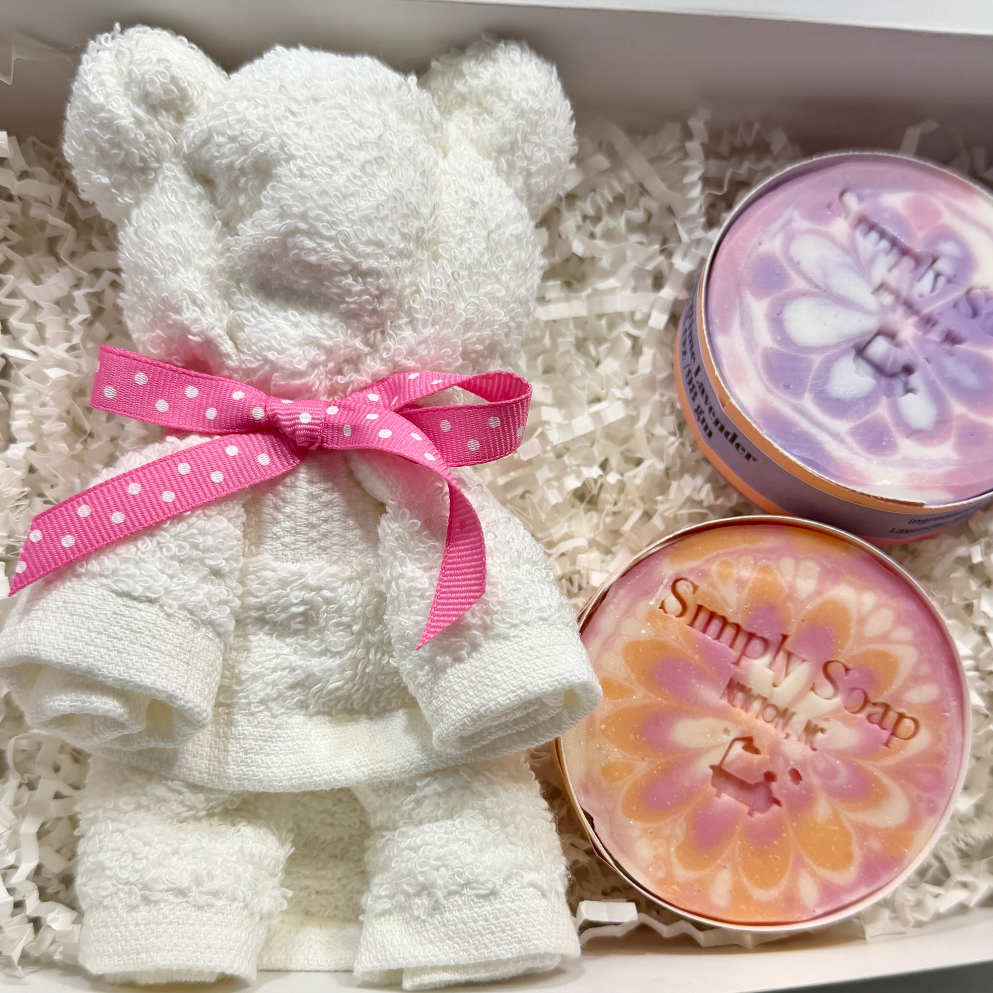 White  washcloth teddy bear with pink bow and two soaps in a box