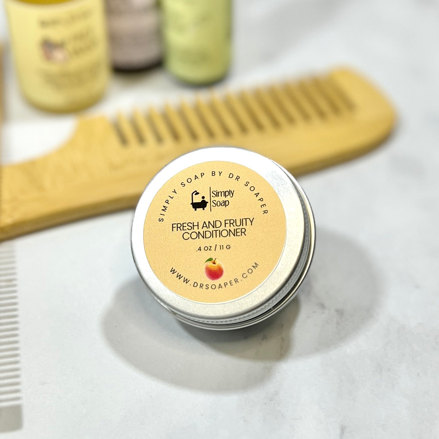 Simply Soap by Dr. Soaper Fresh and Fruity Conditioner jar with a wooden comb on a marble surface