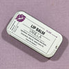Lip balm container labeled 'Vanilla' on a purple background