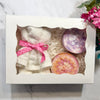 Gift set with a washcloth Teddy bear and two soaps in a decorative box on a marble surface.