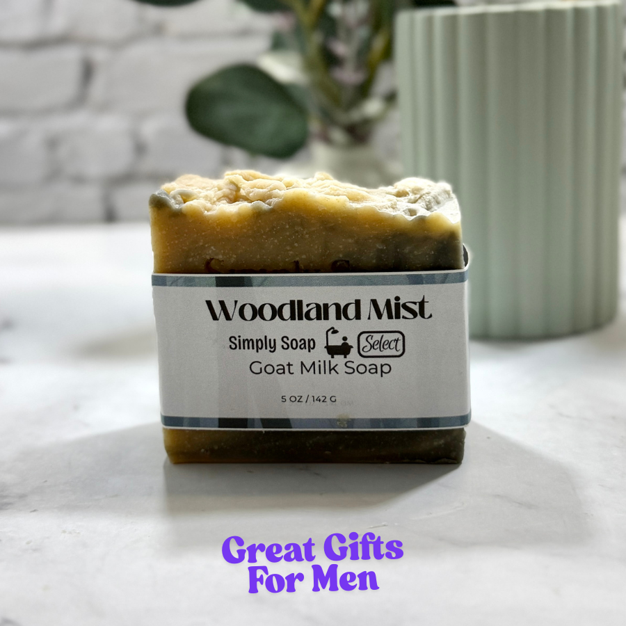 Bar of Woodland Mist goat milk soap on a marble surface with a plant in the background.